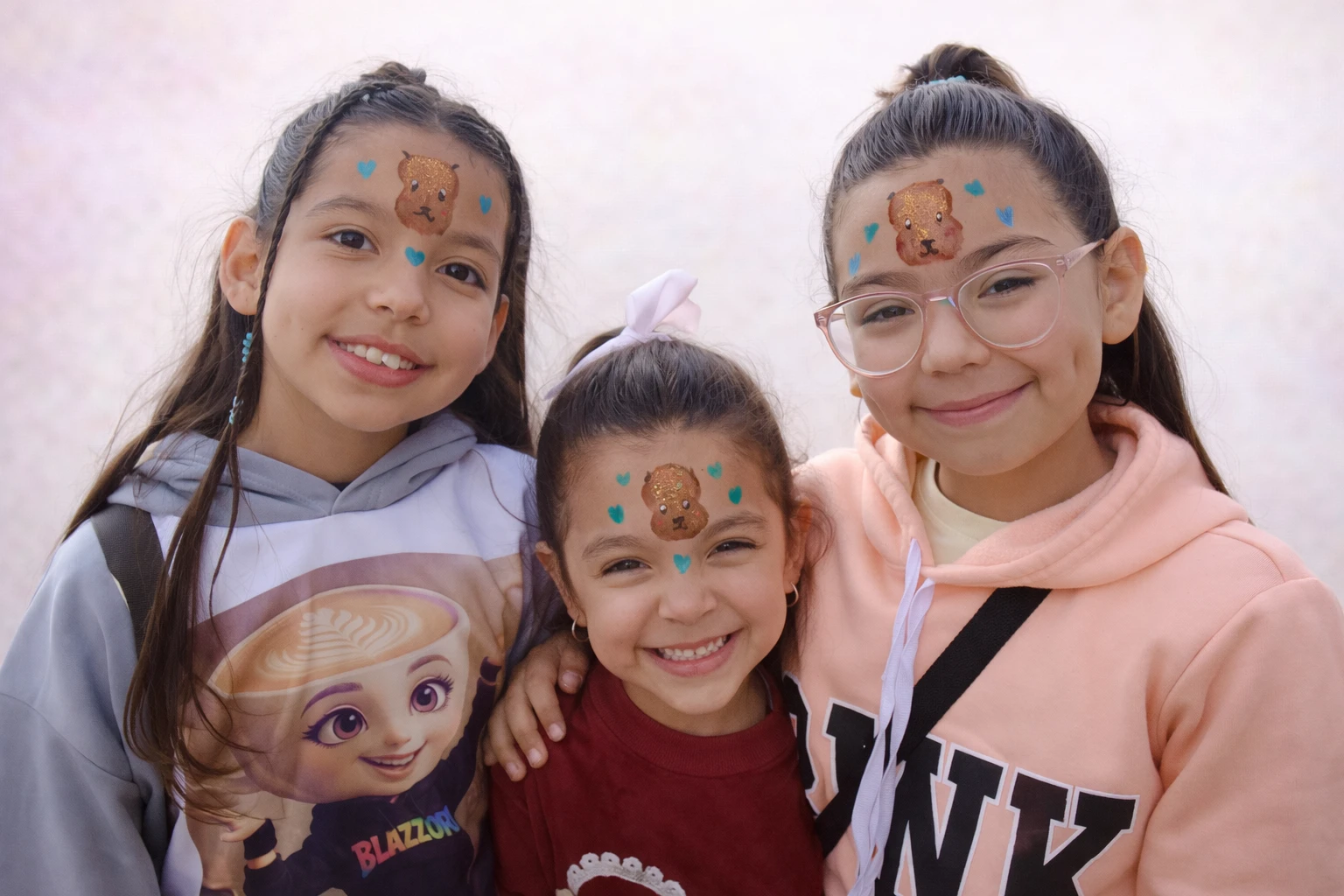 Tres niñas sonriendo con maquillaje de capibara